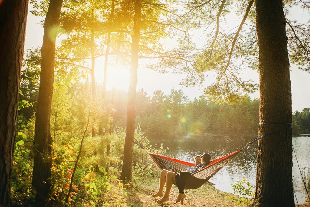 A couple in a hammock near a lake