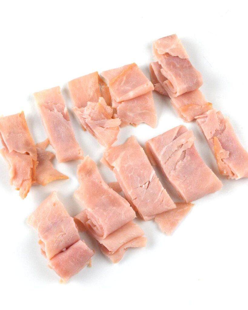 Sliced ham cut into strips on white plate