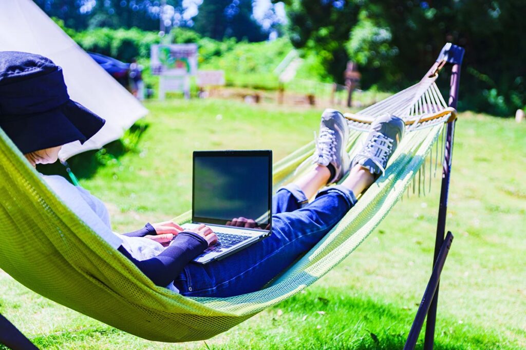 Girl with laptop in a hammock